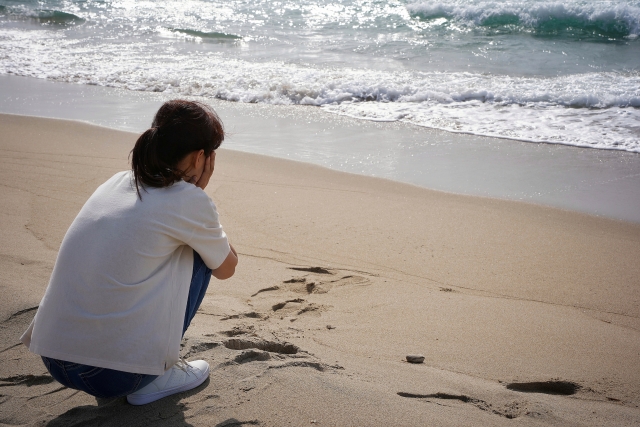 海で落ち込む女性