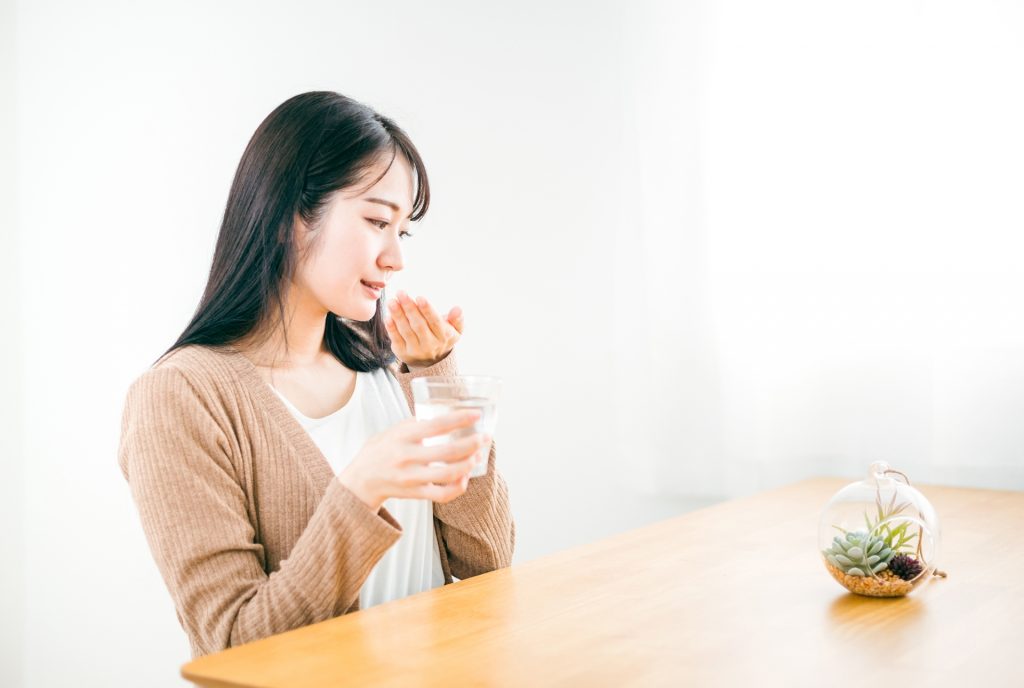 病気で薬・処方箋を飲む日本人女性