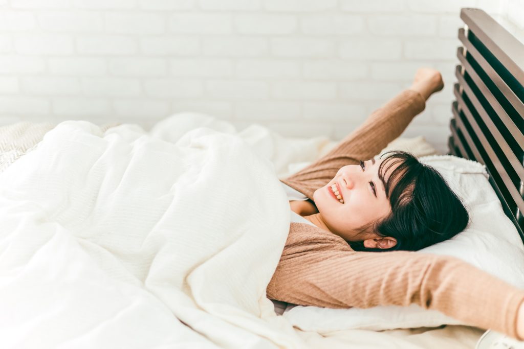 ベッドで起きる女性