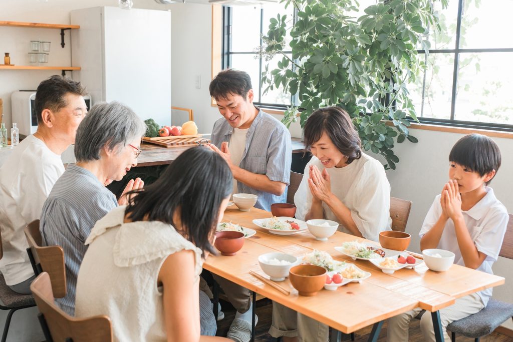 家のダイニングで食事をする3世代家族