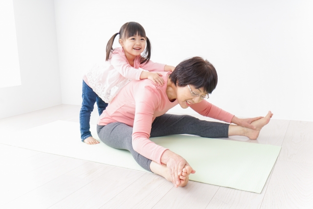 体操をするシニア女性と孫