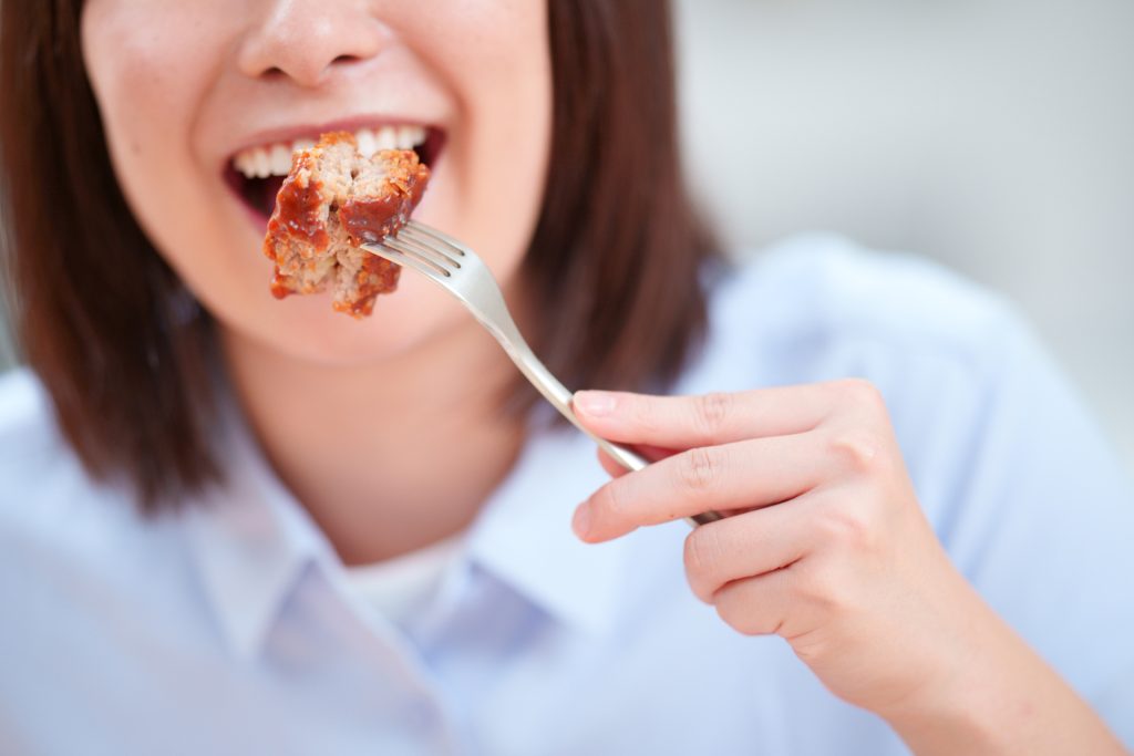 ハンバーグを食べる女性の口元