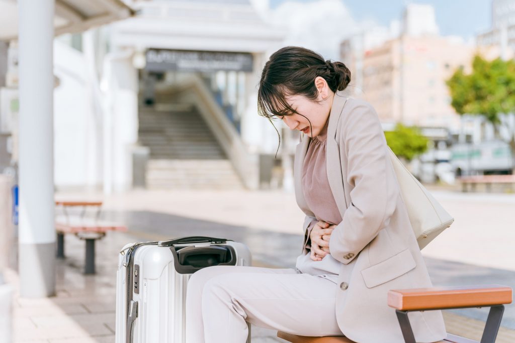 おなかを押さえている女性。婦人科