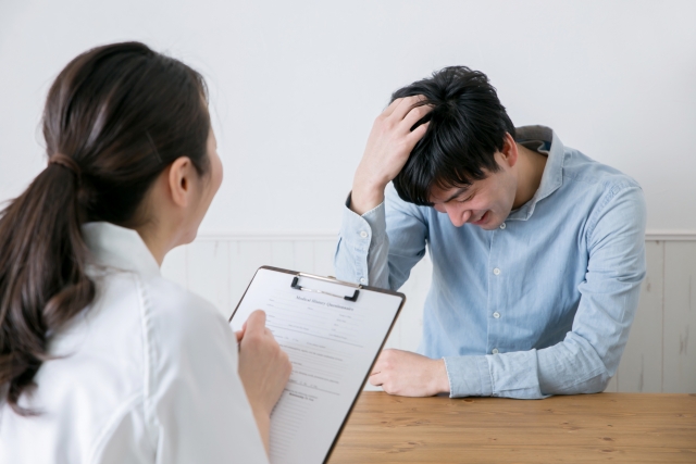 カウンセリングする白衣の女性と男性