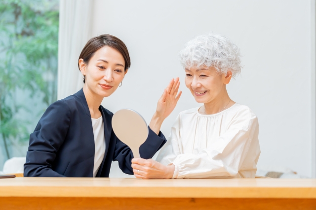 鏡を持って営業をする女性