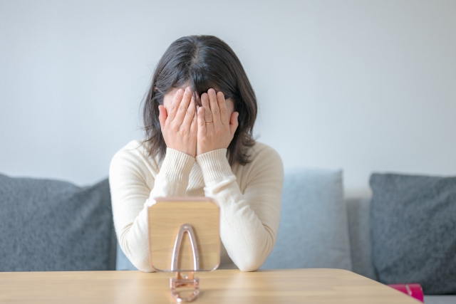 脱毛に悩み顔を手で覆う女性のストレス表情|女性の薄毛・抜け毛の悩みと対策イメージに最適