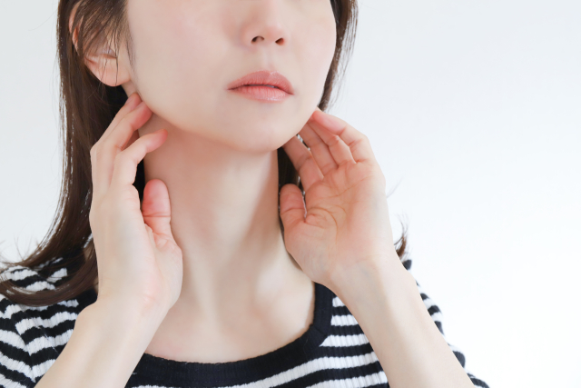 あごのラインにそっと手を添える女性の横顔。美容整形で輪郭を整えることが可能な時代。見た目は変えられても、自分自身と向き合うために本当に必要なものとは——。フェイスライン整形や美容外科に関心のある方に響く一枚。