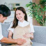 お腹を触る男性と妊婦さん