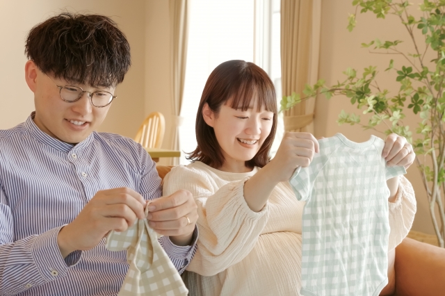 生まれてくる赤ちゃんの洋服を準備している夫婦